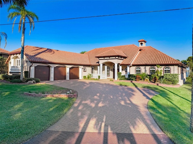 mediterranean / spanish house with a front lawn and a garage