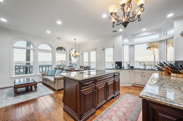 2186 Rockledge Dr, Rockledge, FL 32955 - kitchen with dark brown cabinets, a kitchen island, a chandelier, and black electric stovetop