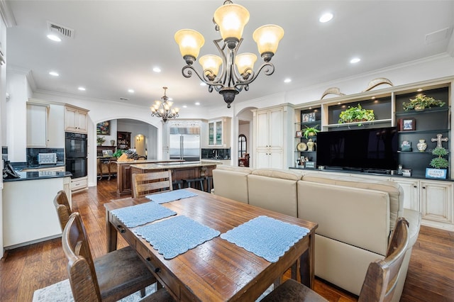 2186 Rockledge Dr, Rockledge, FL 32955 - dining area featuring dark wood-type flooring, crown molding, and a chandelier