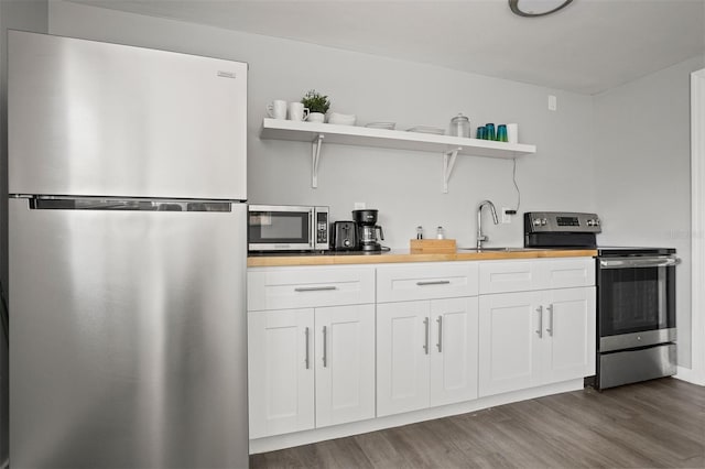 8820 Rocky Creek Dr, Tampa, FL 33615 - kitchen with white cabinetry, dark hardwood / wood-style floors, sink, and stainless steel appliances