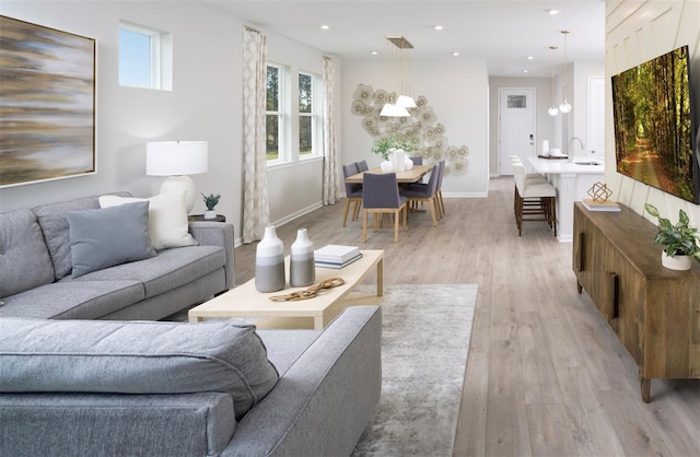 living room featuring sink and light hardwood / wood-style flooring