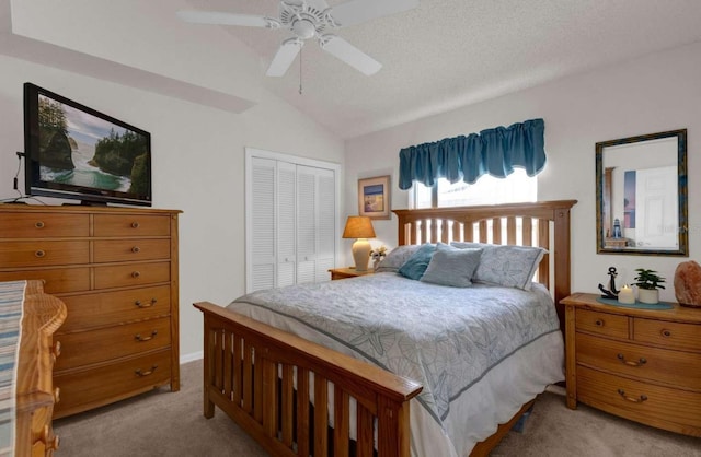 bedroom featuring a ceiling fan, vaulted ceiling, a closet, and light colored carpet