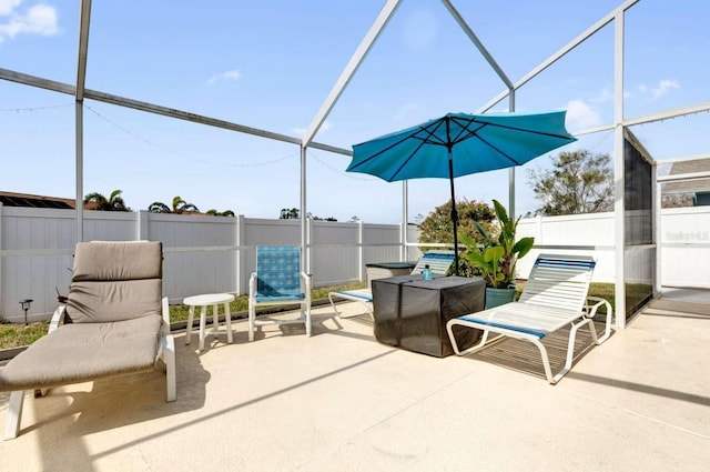 view of patio / terrace with glass enclosure and fence