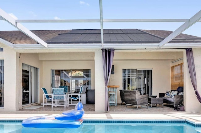 rear view of property with glass enclosure, a patio area, and an outdoor living space