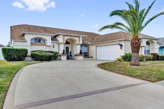 view of front of home featuring a shingled roof, concrete driveway, stucco siding, an attached garage, and a front yard