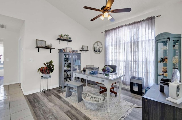 home office with vaulted ceiling, wood finished floors, a ceiling fan, and baseboards