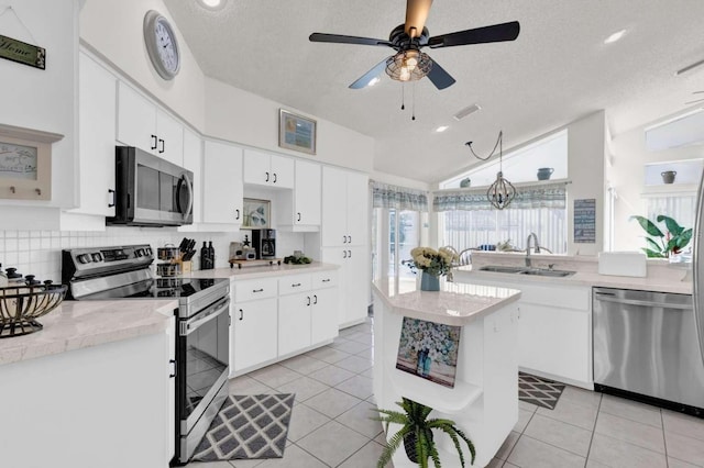 kitchen with light tile patterned floors, a sink, light countertops, appliances with stainless steel finishes, and open shelves