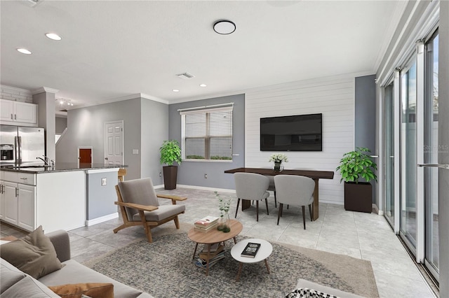 tiled living room featuring crown molding and sink