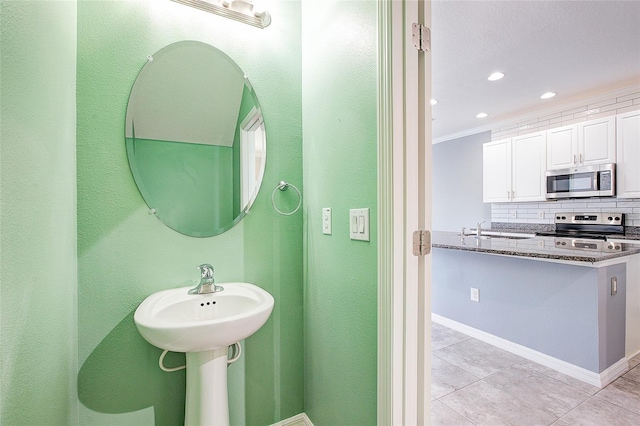 bathroom with crown molding, tile patterned floors, sink, and backsplash