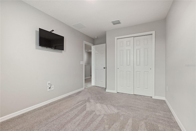 unfurnished bedroom featuring carpet floors and a closet