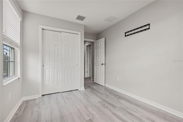 unfurnished bedroom featuring light wood-type flooring and a closet