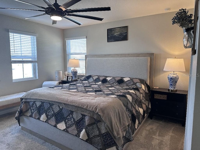 carpeted bedroom featuring ceiling fan and multiple windows