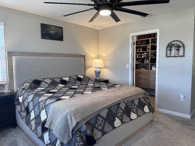 bedroom with a closet, carpet flooring, ceiling fan, and a spacious closet