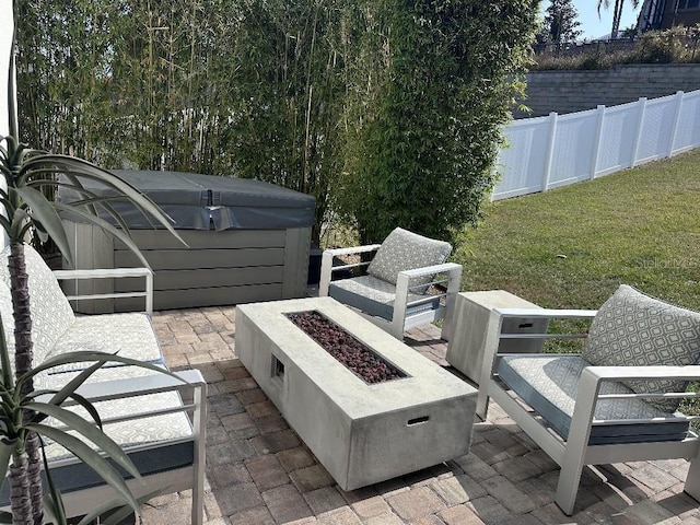 view of patio / terrace featuring a hot tub and a fire pit