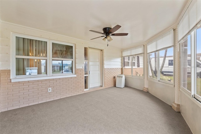 unfurnished sunroom with ceiling fan