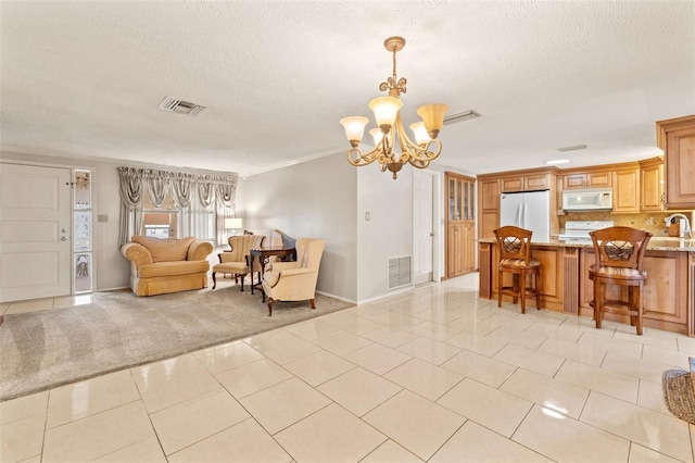 carpeted living room featuring sink, a textured ceiling, and a chandelier