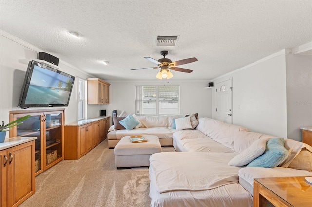 living room with ornamental molding, light colored carpet, ceiling fan, and a textured ceiling