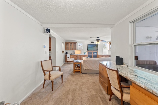 office space with crown molding, ceiling fan, light carpet, and a textured ceiling