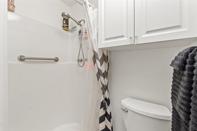 bathroom featuring curtained shower and toilet