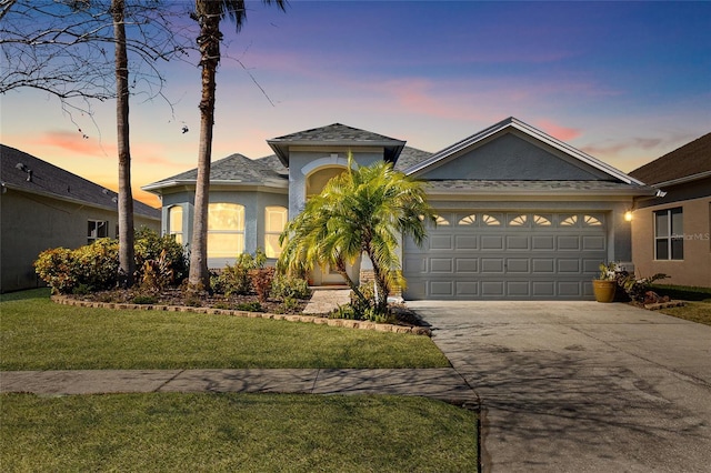 view of front of home featuring a garage and a yard