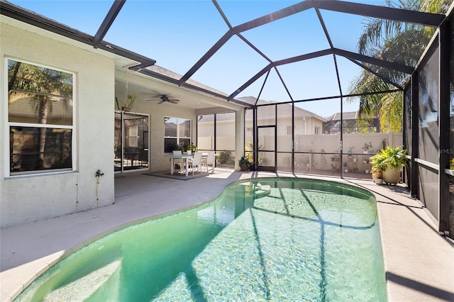 view of swimming pool with ceiling fan, a lanai, and a patio