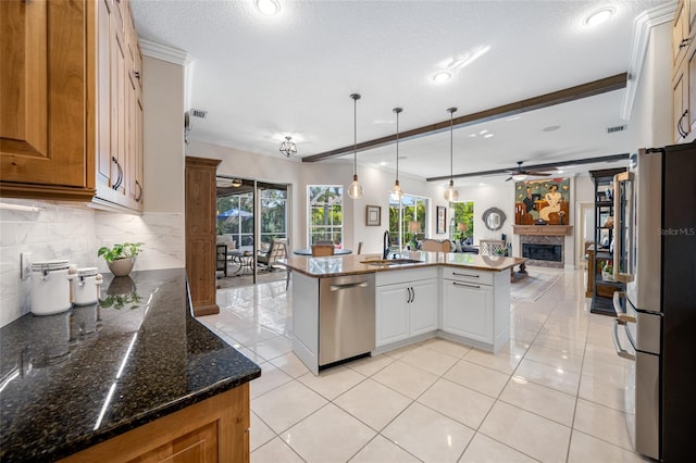 kitchen with sink, a center island, white cabinetry, stainless steel appliances, and hanging light fixtures