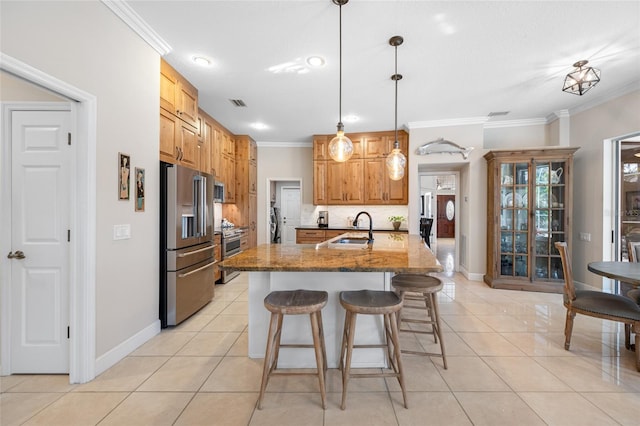 kitchen featuring appliances with stainless steel finishes, light tile patterned floors, hanging light fixtures, and light stone countertops