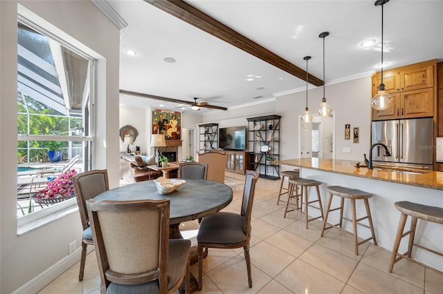 tiled dining room featuring sink, crown molding, ceiling fan, and beam ceiling