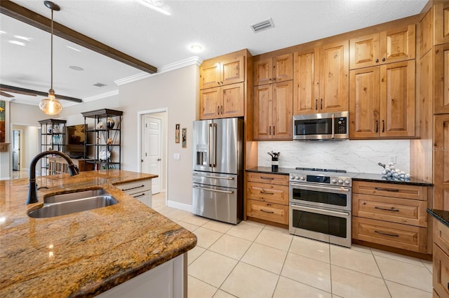 kitchen featuring hanging light fixtures, premium appliances, decorative backsplash, sink, and dark stone countertops