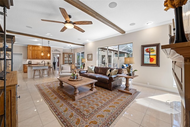 living room featuring light tile patterned floors, crown molding, and sink