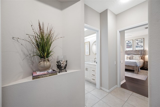 hall with light tile patterned floors and sink