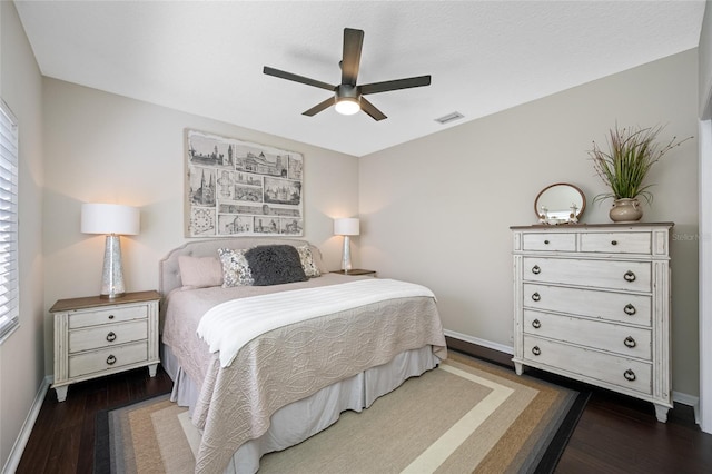 bedroom with multiple windows, dark wood-type flooring, and ceiling fan