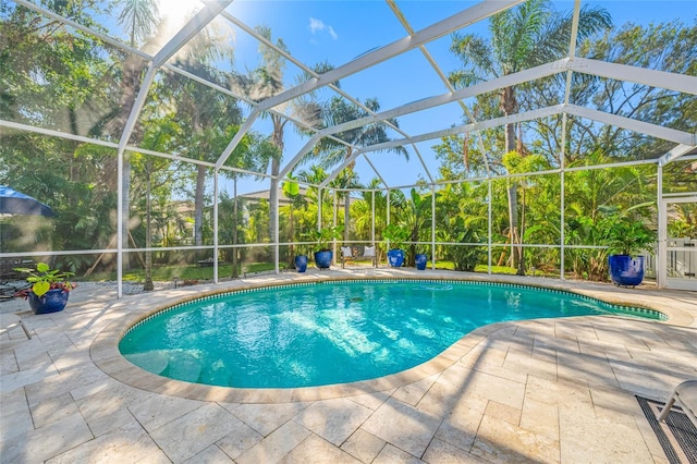 view of pool featuring glass enclosure and a patio