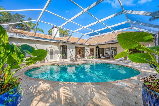 view of pool featuring a patio, ceiling fan, and glass enclosure