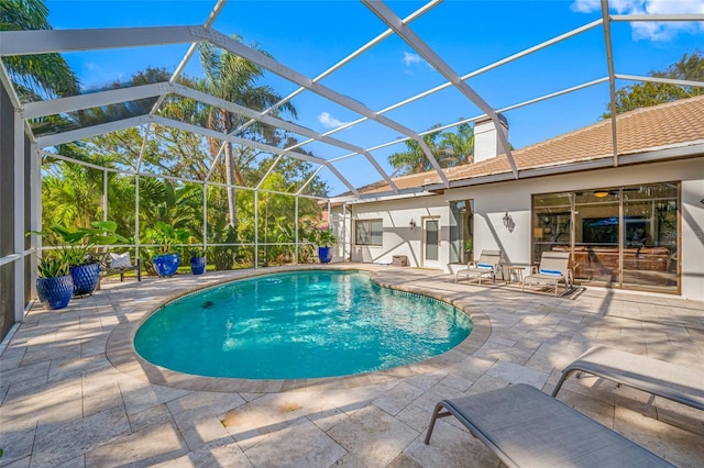 view of swimming pool featuring a lanai and a patio area