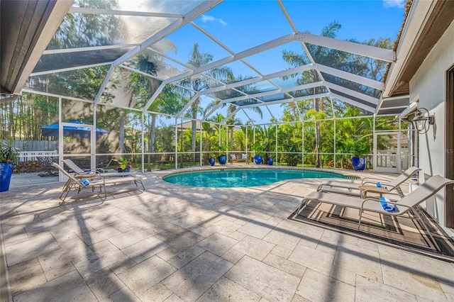 view of pool featuring glass enclosure and a patio