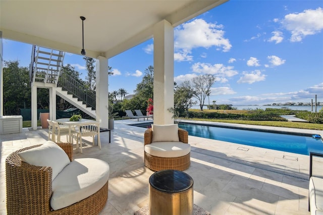 view of patio / terrace with stairway, an outdoor pool, and outdoor dining space