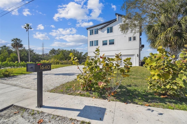 view of front of house featuring gravel driveway and stucco siding