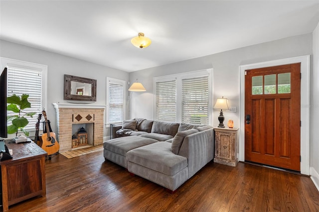 living room with dark hardwood / wood-style floors, a wealth of natural light, and a fireplace