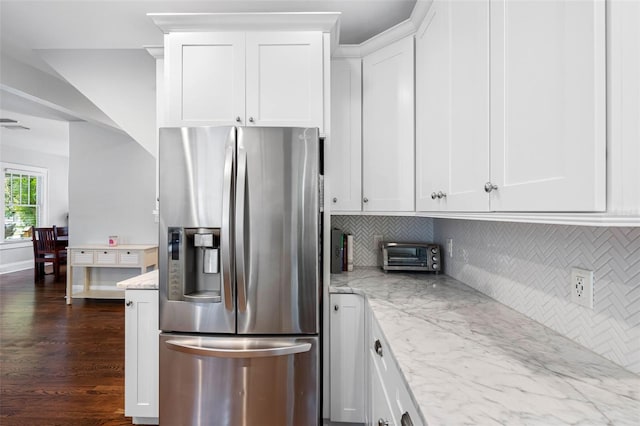 kitchen with white cabinetry, light stone countertops, decorative backsplash, and stainless steel fridge with ice dispenser