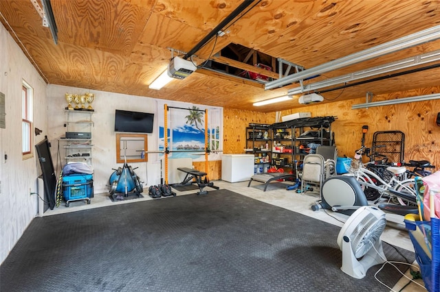 garage with a garage door opener, wooden walls, and wooden ceiling