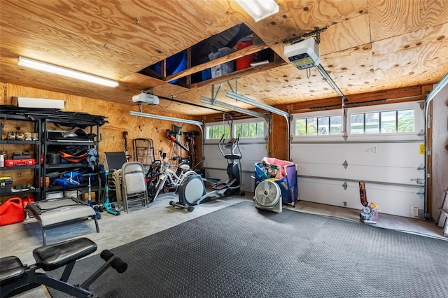 garage with a garage door opener and wood walls