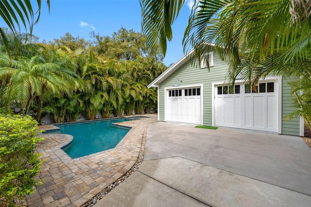 view of pool featuring an outbuilding and a garage