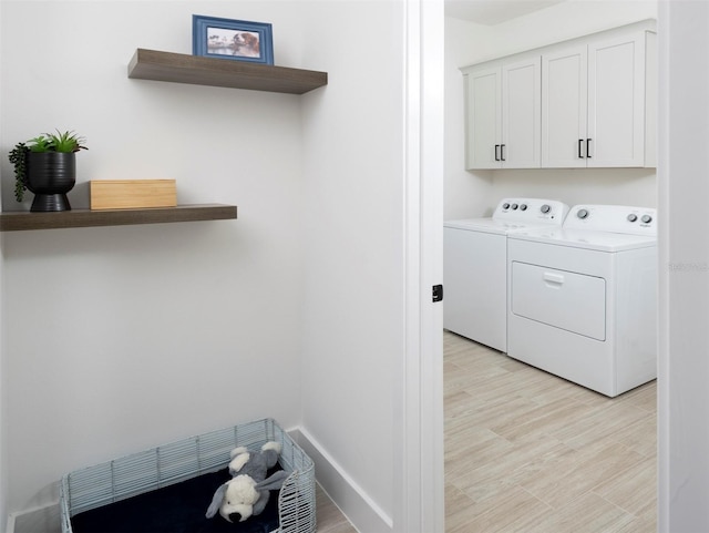 laundry area featuring cabinets, independent washer and dryer, and light wood-type flooring