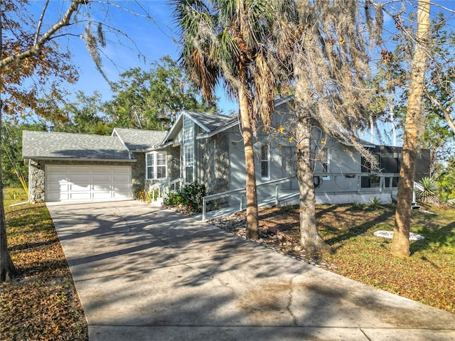 view of front of house featuring stone siding, concrete driveway, a shingled roof, and an attached garage