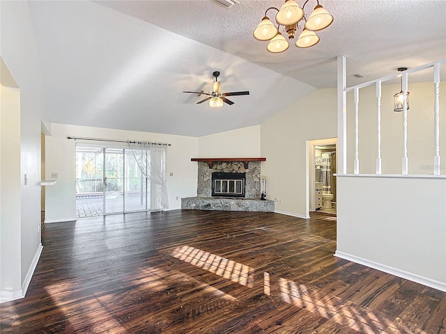 unfurnished living room with lofted ceiling, a textured ceiling, ceiling fan with notable chandelier, dark wood-style flooring, and a fireplace