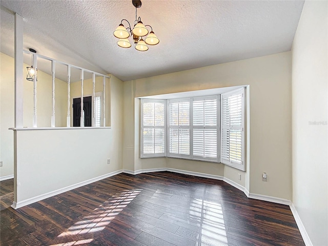 empty room featuring vaulted ceiling, dark wood-style flooring, baseboards, and a notable chandelier