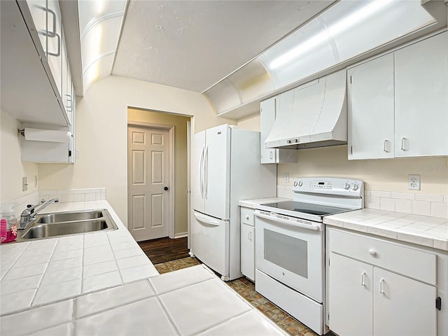 kitchen with white appliances, a sink, tile countertops, and under cabinet range hood