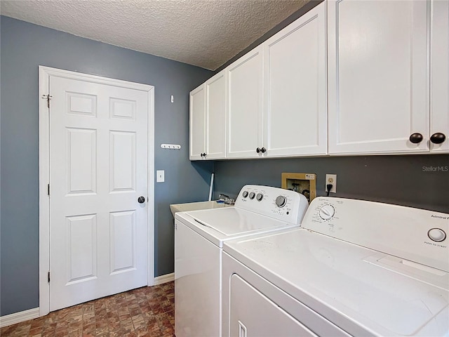 laundry room with washing machine and clothes dryer, cabinet space, a sink, a textured ceiling, and baseboards