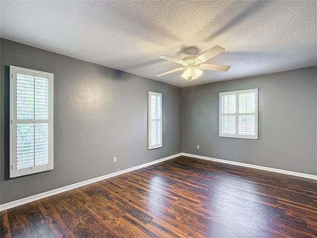 unfurnished room with ceiling fan, dark wood-type flooring, a textured ceiling, and baseboards